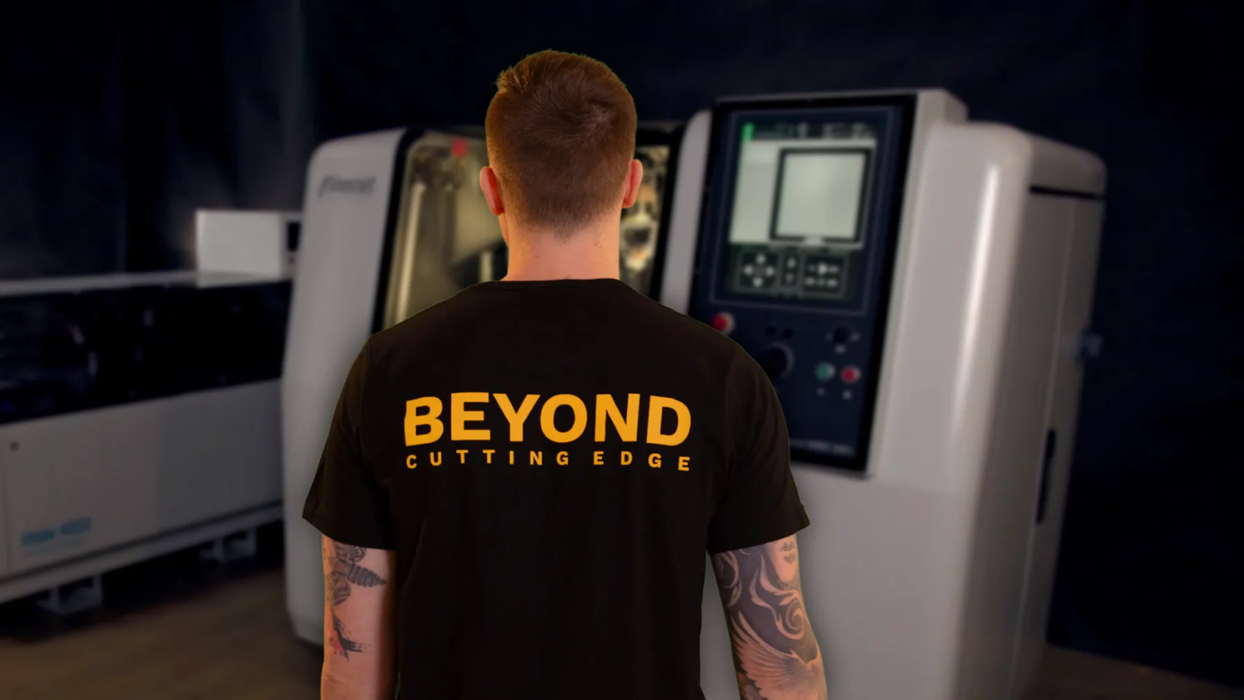 Finecut operator wearing a Beyond Cutting Edge shirt in front of a Finecut system