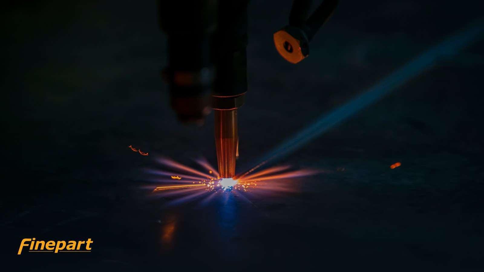 Industrial laser cutting head melting metal with sparks — a thermal cutting process